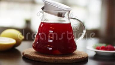 特写一个有热水和花红茶的茶壶，动作慢.. 一只手<strong>正在</strong>木器上用茶壶装饰茶